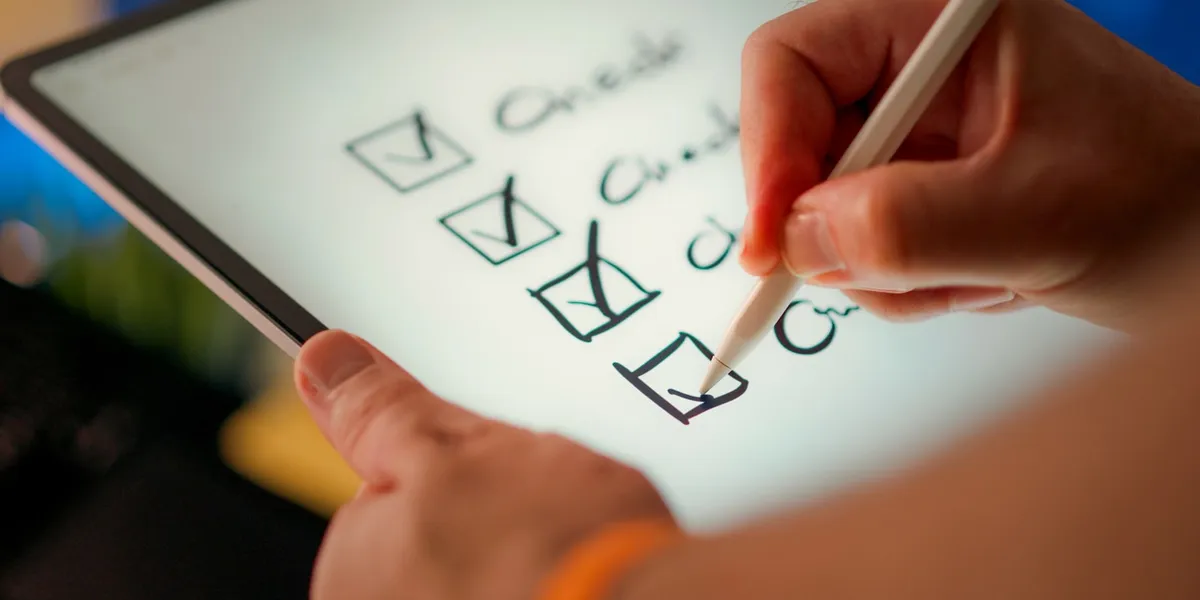 A hand marks off items on a checklist.
